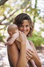 Caucasian mother holding baby outdoors