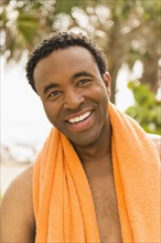 Black man wearing towel on beach