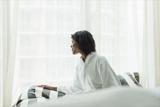 African American woman looking out window