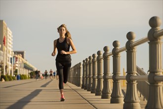 Caucasian teenage girl running on boardwalk