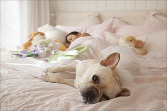 Asian girl sleeping in bed with dog