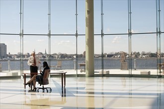 Business people working in large office with glass wall