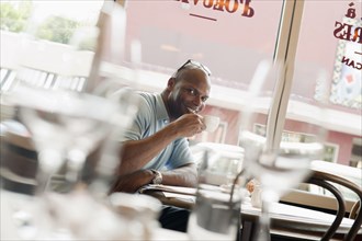 African American man drinking coffee in restaurant