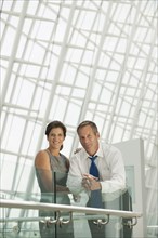 Business people leaning on railing