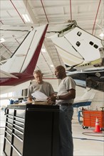Men working in airplane hangar