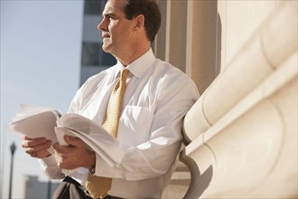 Caucasian businessman looking at paperwork outdoors