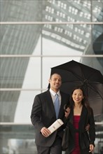 Business people standing together with umbrella