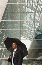Caucasian businessman underneath umbrella