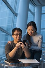 Asian couple looking at cell phone