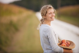 Caucasian woman picking fruit on rural road