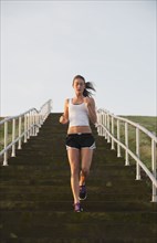 Caucasian woman running down steps