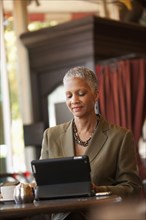 African American businesswoman using digital tablet in cafe