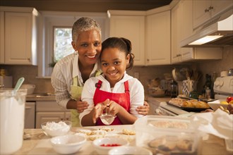 Woman and granddaughter baking in kitchen