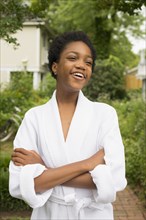 African American girl wearing bathrobe in backyard