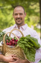 Caucasian man carrying basket of fresh produce
