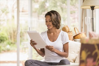 African American woman reading paperwork