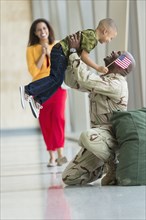 African American soldier greeting family in airport