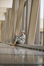 African American soldier using cell phone in airport
