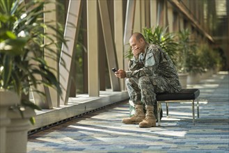 Caucasian soldier using cell phone in airport