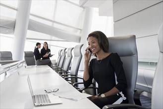 Businesswoman using cell phone in conference room