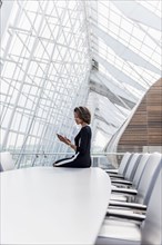 Black businesswoman using cell phone in conference room