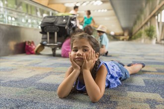 Bored girl laying on floor of airport