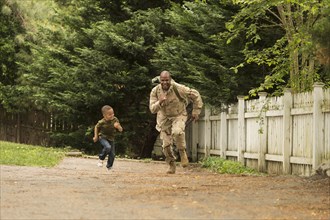 African American soldier running in race with son