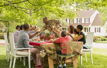 Multi-generation family toasting with lemonade at picnic