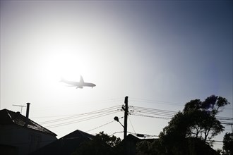 Airplane flying over neighborhood rooftops