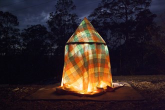 Glowing tent in rural field