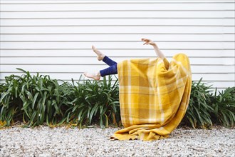 Caucasian woman in blanket falling outdoors