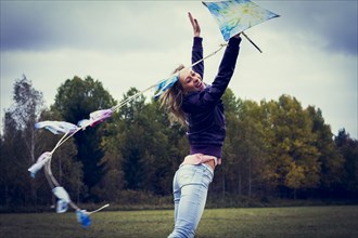 Woman flying kite in field