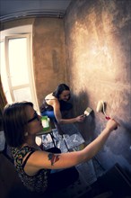 Women painting wall