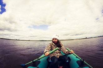 Caucasian girl rowing canoe on lake