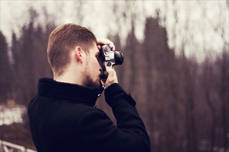 Caucasian man taking photograph outdoors