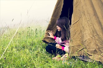 Caucasian girl sitting in camp tent