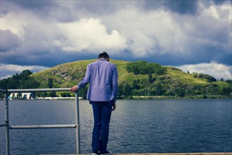 Caucasian man standing on dock at lake