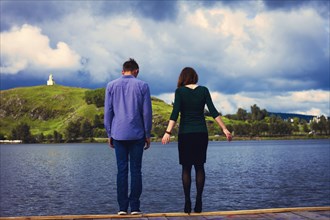 Caucasian couple standing on dock at lake