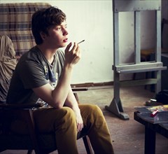 Caucasian man smoking cigarette in living room