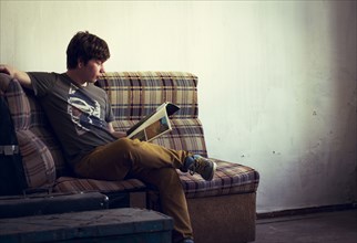 Caucasian man reading in living room