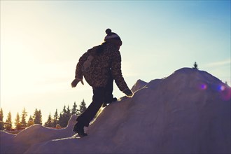 Caucasian girl climbing snowy hill