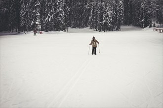 Caucasian girl cross-country skiing in snowy field