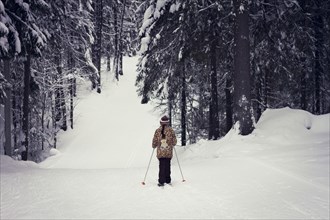 Caucasian girl cross-country skiing in forest