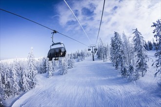 Chair lift gondolas over snowy slopes