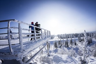 Caucasian snowboarders standing on snowy platform