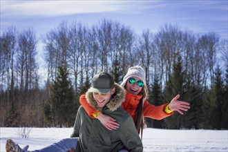 Caucasian couple playing in snowy field