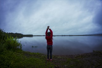 Caucasian teenage girl stretching by remote lake
