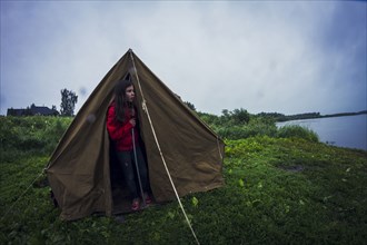 Caucasian girl standing in tent at campsite