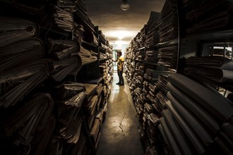 Caucasian man searching old newspapers in library archive