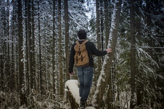 Caucasian hiker standing in snowy forest